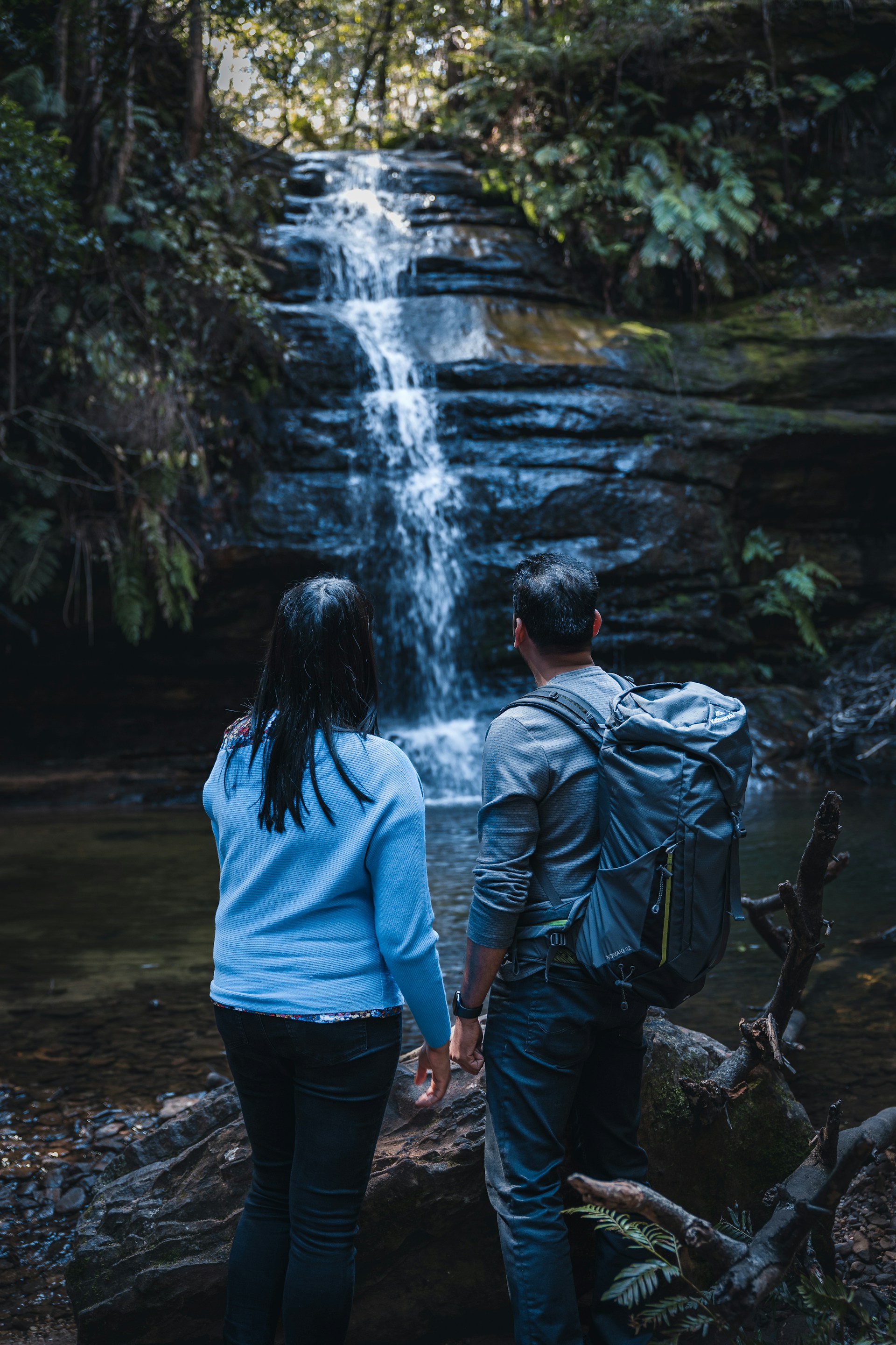 Two people watching waterfall
